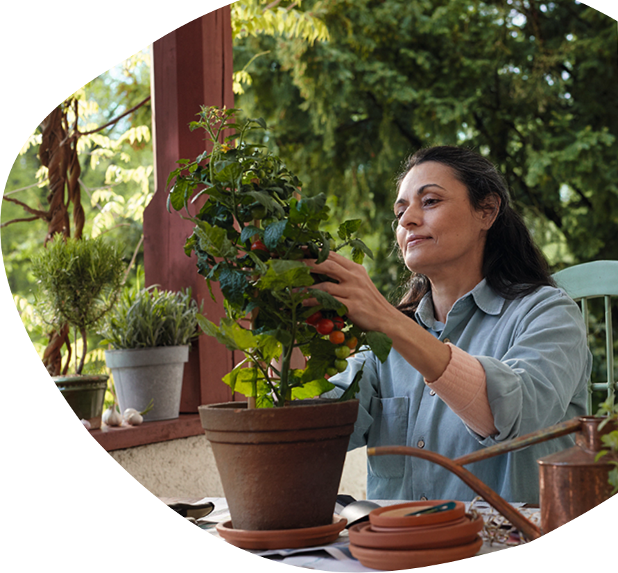Une femme assise à une table qui s'occupe d'une plante