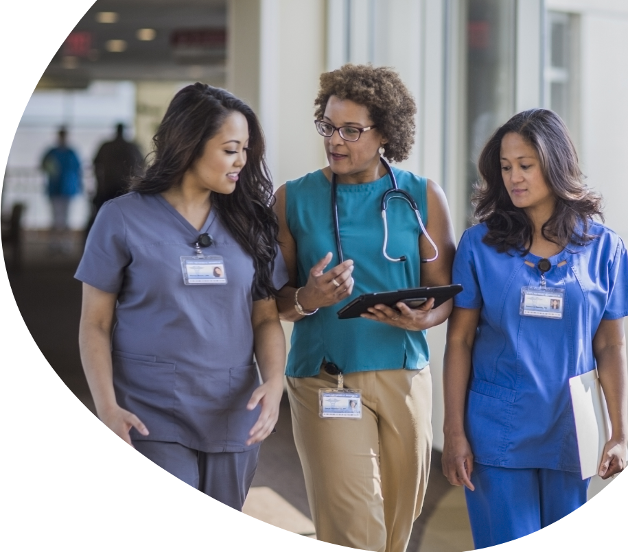 A female doctor speaking to two female nurses while walking